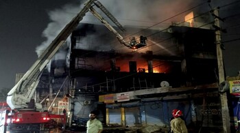 Fire officials try to douse a fire in a four storied building, in New Delhi. Dozens of people have been rescued from the commercial building, mainly shops, in the Mundka area in the western part of New Delhi. (AP Photo/Dinesh Joshi)