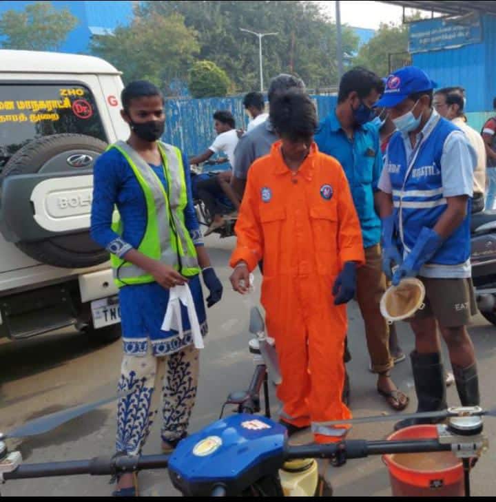 From left: Pragya (in green jacket) and Sai (in orange overalls) inspecting a drone before taking off