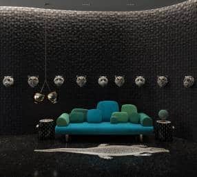 Porcelain animal masks on black walls provide a dramatic backdrop to a couch done up in various hues of blue. Pix credit: Sanjyt Syngh Objects+Spaces
