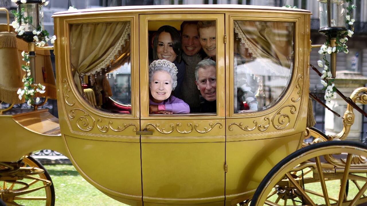 Cousins from the Goldhawk and Ganesan families pose whilst wear masks depicting members of the Royal Family as they play in a gold carriage in a park during Platinum Jubilee celebrations in London, Britain, June 1. (Image: Reuters)