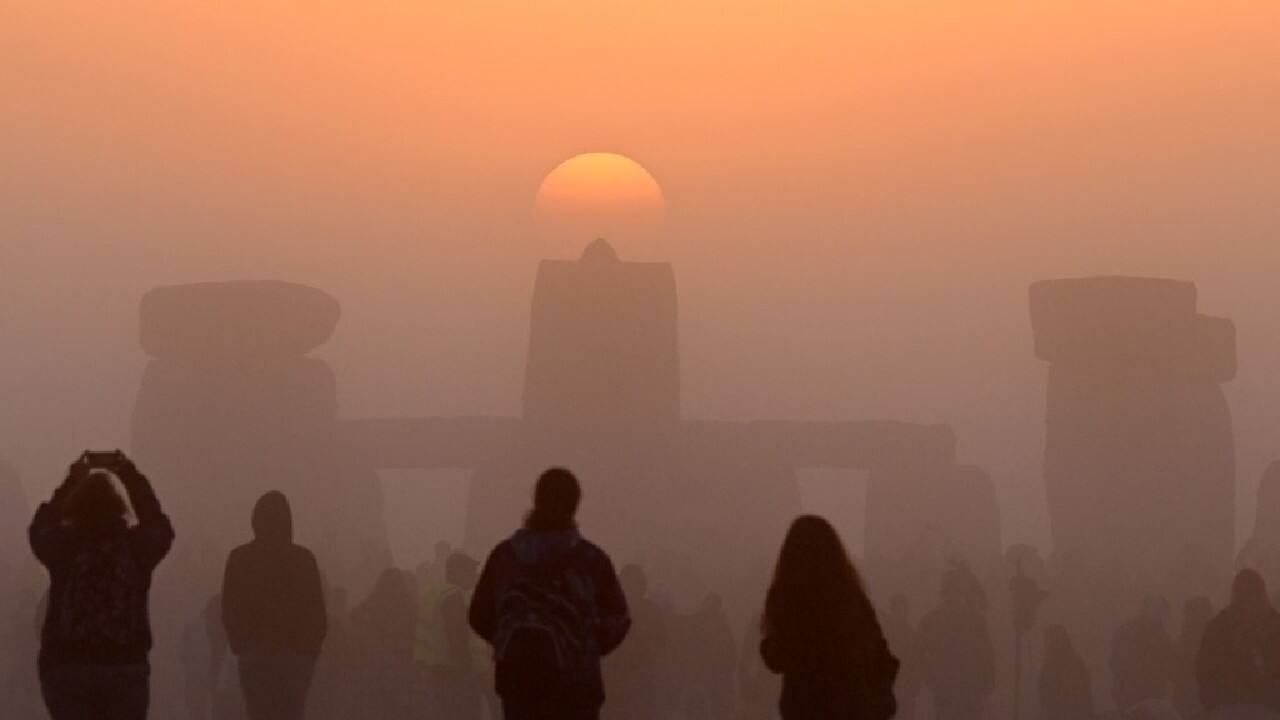 Revellers celebrate the Summer Solstice as the sun rises at Stonehenge, near Amesbury, in Wiltshire, southern England on June 21, in a festival, which dates back thousands of years, celebrating the longest day of the year when the sun is at its maximum elevation. (Image: AFP)