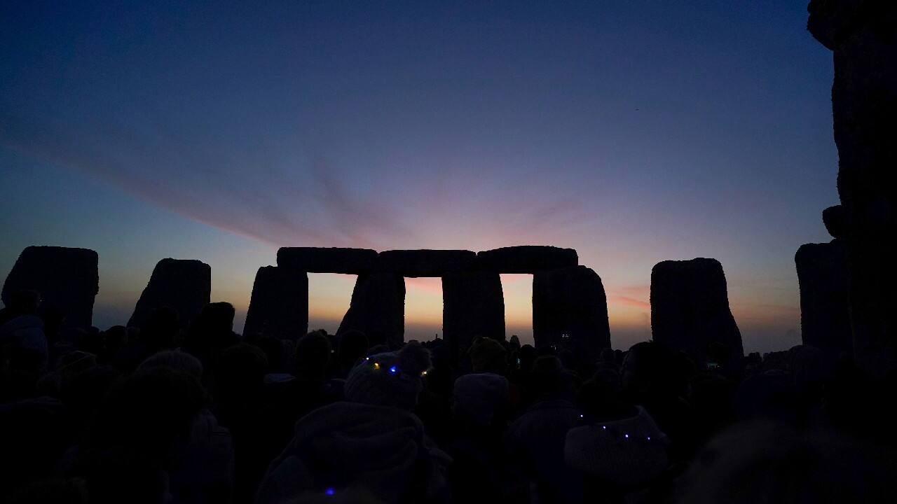 The sun begins to rise above the stones as people gather at sunrise to take part in the Summer Solstice festivities at Stonehenge in Wiltshire, England. (Image: AP)