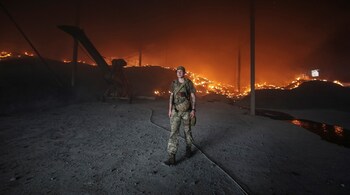 A Ukrainian serviceman walks as seeds burn in a grain silos after it was shelled repeatedly, amid Russia's invasion of Ukraine, in Donetsk region, Ukraine May 31. (Image: Reuters)