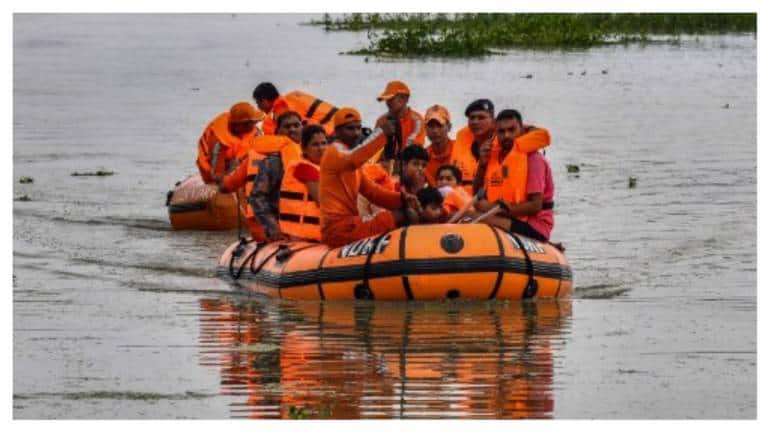 National Disaster Response Force (NDRF) personnel rescue flood-affected villagers at Phuthimari of Kamrup district, in India's Assam state on June 19, 2022.
