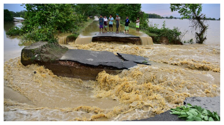Flood-affected people stand on a road damaged by the flood waters after heavy rains in Nagaon district, Assam, on May 19, 2022. (Photo: Anuwar Hazarika/Reuters) Flood-affected people stand on a road damaged by the flood waters after heavy rains in Nagaon district, Assam, on May 19, 2022. (Photo: Anuwar Hazarika/Reuters)