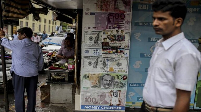 A pedestrian walks past a currency exchange shop in Mumbai, India, on Thursday, June 28, 2018. The Indian rupee slumped to an all-time low as a resurgence in crude prices and the emerging-market selloff took a toll on the currency of the world's third-biggest oil consumer. Photographer: Dhiraj Singh/Bloomberg