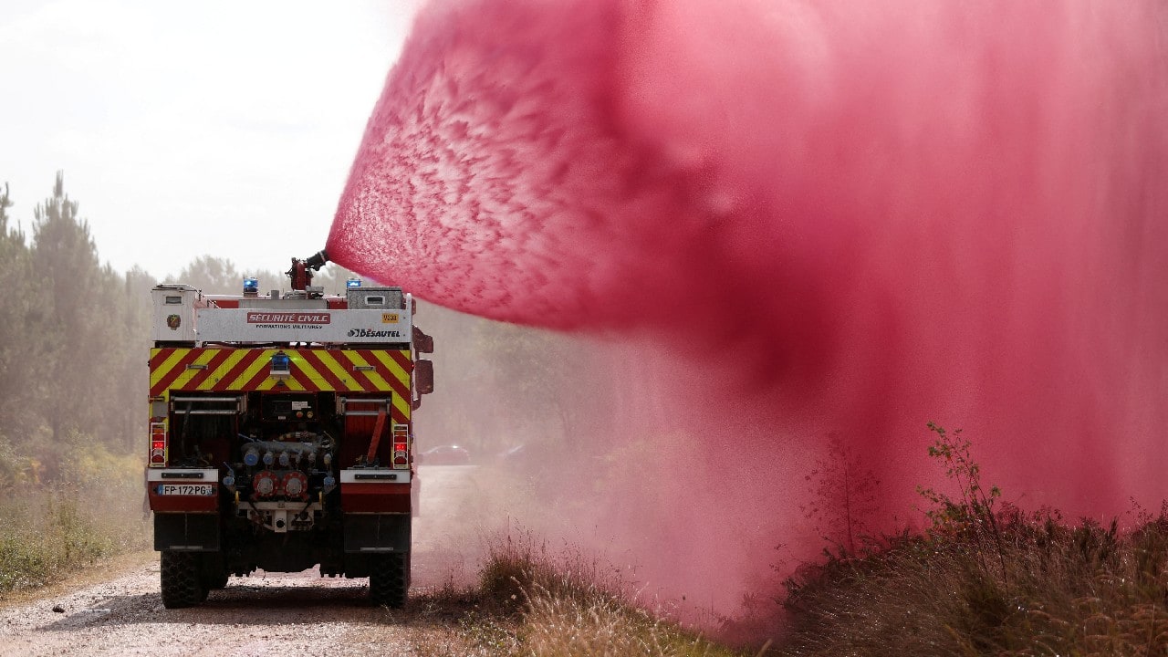 Firefighters spray flame retardant to extinguish ground fire on land in Hostens in the Gironde region of southwestern France, July 22. (Image: Reuters)
