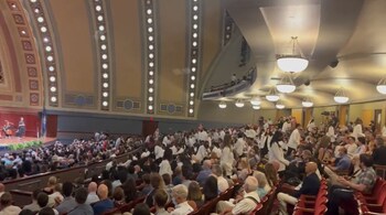 Michigan University students walk out of their induction ceremony on July 24. (Image credit: Screengrab from video tweeted by @PEScorpiio)