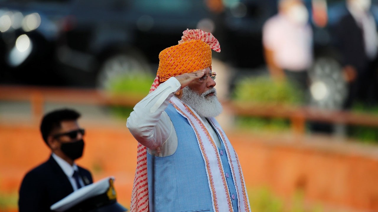 2021 | Last year, he wore a saffron turban with red patterns and a long pink trail. The Prime Minister had sported a saffron and cream headgear with a long tail. He had paired the 'safa' with a half-sleeve kurta and a fitted churidar. He also wore a white scarf with a saffron border that he used to cover his mouth and nose in view of the COVID-19 pandemic. (Image: Reuters)