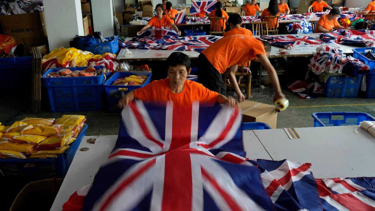 A worker packs British flags to prepare for shipping at the Shaoxing Chuangdong Tour Articles Co. factory in Shaoxing, in eastern China's Zhejiang province, September 16. Ninety minutes after Queen Elizabeth II died, orders for thousands of British flags started to flood into the factory south of Shanghai. (Image: AP)