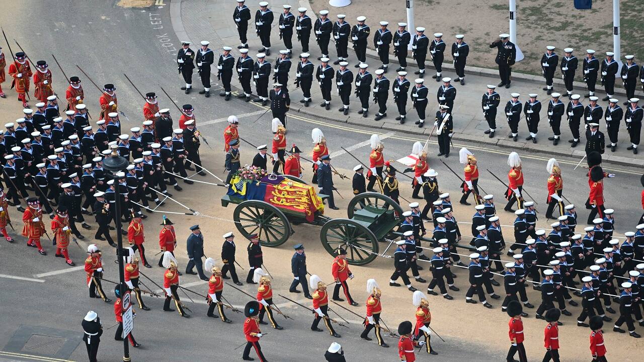 In this photo issued by UK Parliament, the State Gun Carriage carrying the coffin of Queen Elizabeth II, draped in the Royal Standard with the Imperial State Crown and the Sovereign's orb and sceptre, leaves Westminster Abbey, London, after the funeral service, Monday Sept. 19, 2022. (Jessica Taylor/UK Parliament via AP)