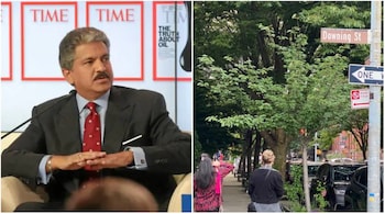Anand Mahindra and a sign pointing to New York's Downing Street.