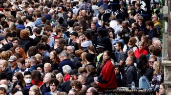 Members of the public gather to watch the procession of Queen Elizabeth II's coffin, from the Palace of Holyroodhouse to St Giles Cathedral, on the Royal Mile on Monday.
