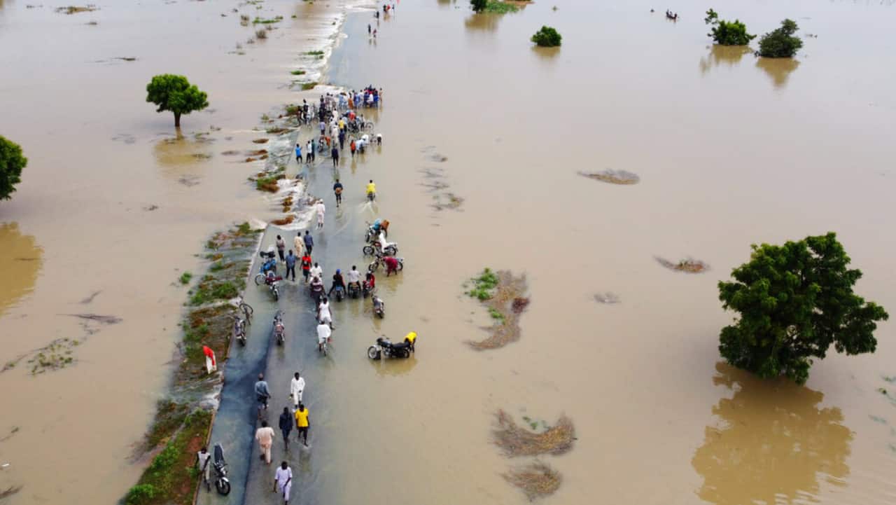 People walk through floodwaters after heavy rainfall in Hadeja, Nigeria, Monday, Sept 19, 2022. Nigeria is battling its worst floods in a decade with more than 300 people killed in 2021 including at least 20 this week.