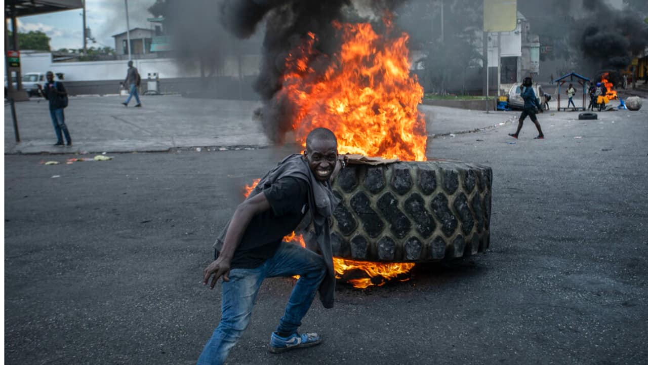 A protester adds a tire to a burning barricade during a protest against fuel price hikes and demands for Haitian Prime Minister Ariel Henry to step down in Port-au-Prince, Haiti.