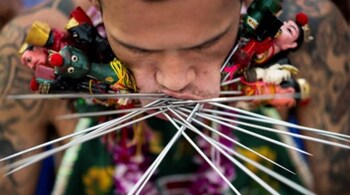 A devotee of the Loem Hu Thai Su shrine has multiple skewers pierced through his cheeks during the annual Vegetarian Festival in Phuket.