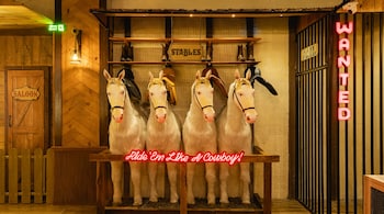 The ranch-inspired interiors include fake horses and chandeliers crafted from wagon wheels.