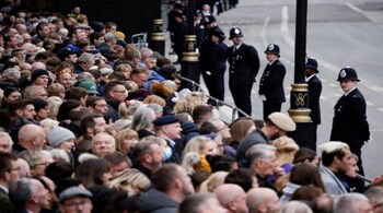 Police officers stand guard as mourners gather ahead of Britain's Queen Elizabeth II's State funeral in London on September 19.