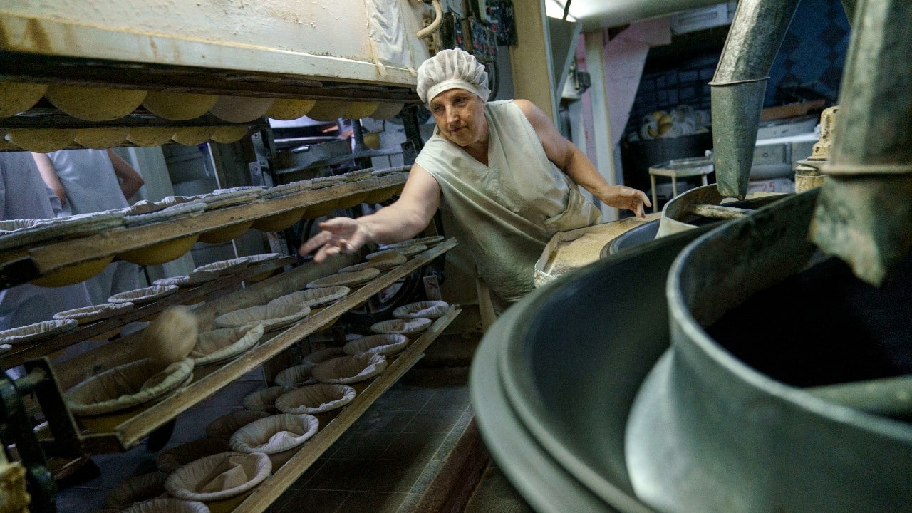 Another employee, Olena Nahorna, 48, agrees. “We are not afraid. We bake bread, because the people, our military, our defenders, need bread,” Nahorna says with a smile, moving the dough to the oven. (Image: AP)