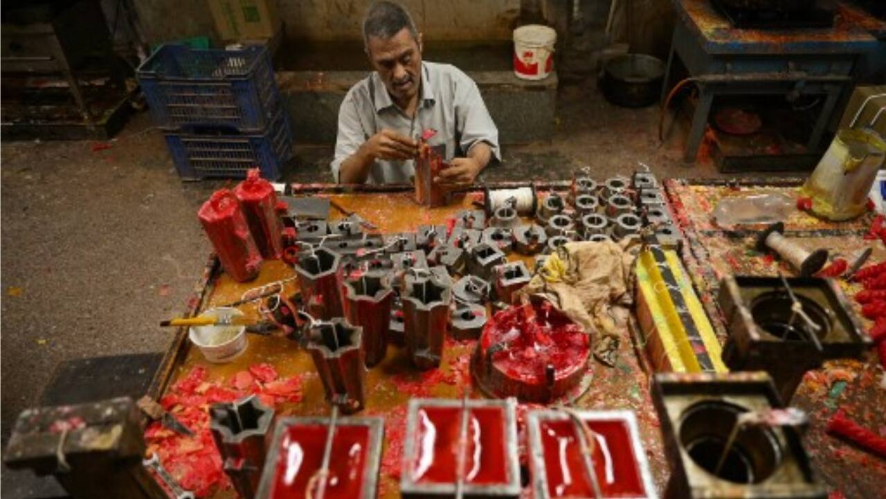 A visually impaired man is engaged in a process of making candles to be used for decorations during Diwali, at a workshop inside the premises of Blind Relief Association in New Delhi.