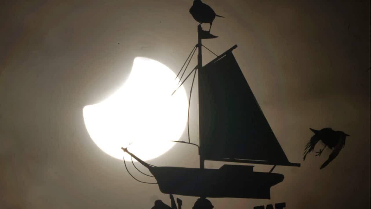 A partial solar eclipse is visible over Cullercoats Watch House in North Shields, England, Tuesday, October 25.