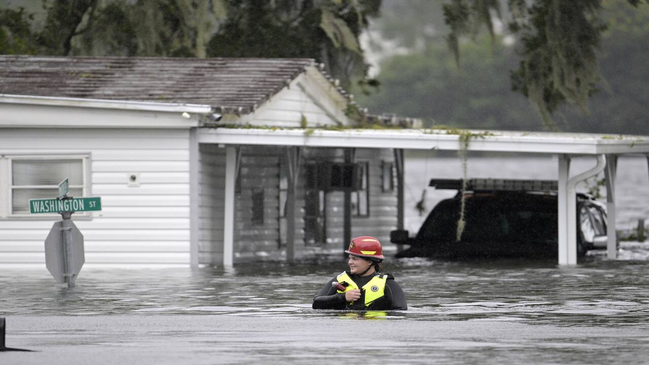 A first responder with Orange County Fire Rescue makes her way through floodwaters looking for residents of a neighborhood needing help in the aftermath of Hurricane Ian, in Orlando, Florida on September 29. 