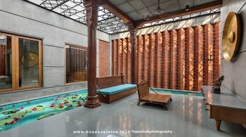 The puja room surrounded by water at the Rathod house in Vadodara with wooden columns sourced from an antique shop in Ahmedabad.