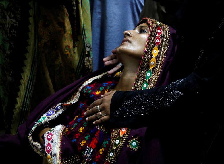 Pakistan Floods: A flood-affected woman and suffering from fever, is taken care by a relative as she waits for medical assistance at Sayed Abdullah Shah Institute of Medical Sciences in Sehwan, Pakistan, September 29. Image: REUTERS/Akhtar Soomro)
