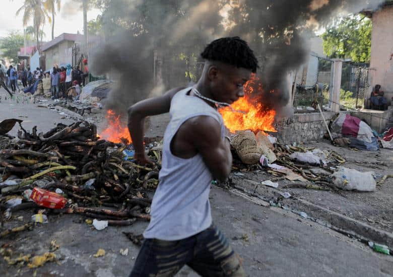 Rising fuel prices: A man runs past a burning street barricade during a protest against the government and rising fuel prices, in Port-au-Prince, Haiti, October 3. (REUTERS/Ralph Tedy Erol)