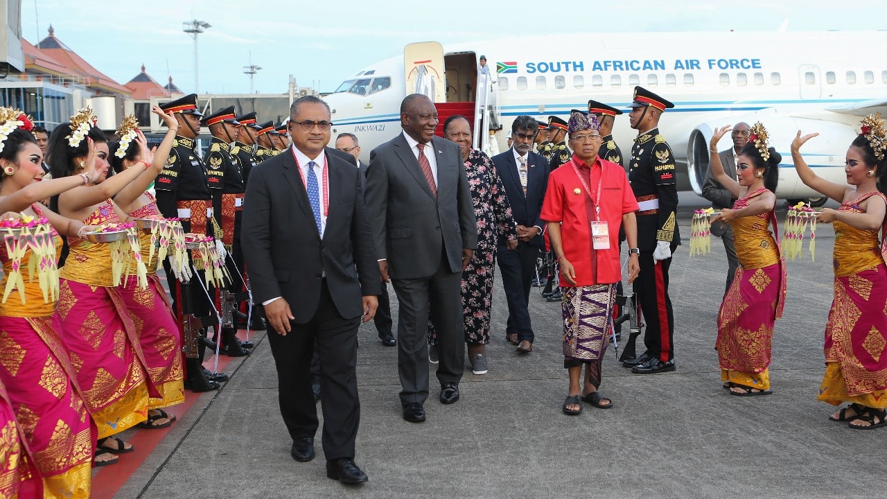 South Africa's President Cyril Ramaphosa, center, is welcomed by performers as he arrives at the Ngurah Rai International Airport ahead of the G20 Summit in Bali, Indonesia, November 14. (Image: AP)