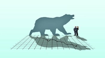 A businessman and a businesswoman look up at a large bear as it casts its shadow across a stock market chart. (Image credit: Getty Images)