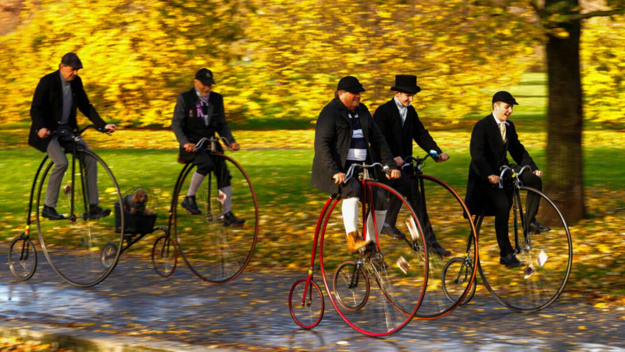 Enthusiasts dressed in historical costumes enjoy a ride on their penny-farthing bicycles during their traditional race in Prague, Czech Republic.