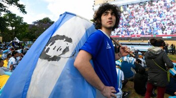 An Argentina soccer fan holds a Maradona flag,