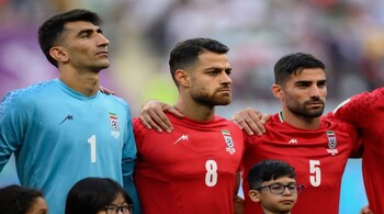 DOHA, QATAR - NOVEMBER 21: (L-R) Alireza Beiranvand, Morteza Pouraliganji and Morteza Pouraliganji of IR Iran line up for the national anthem prior to the FIFA World Cup Qatar 2022 Group B match between England and IR Iran at Khalifa International Stadium on November 21, 2022 in Doha, Qatar. (Photo by Matthias Hangst/Getty Images)