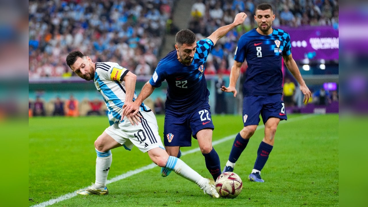 Argentina's Lionel Messi, left, and Croatia's Josip Juranovic battle for the ball during the World Cup semifinal soccer match between Argentina and Croatia at the Lusail Stadium in Lusail, Qatar. (Source: AP)