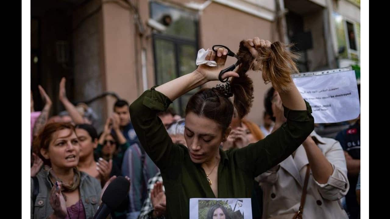 Nasibe Samsaei, an Iranian woman living in Turkey, cuts her ponytail off during a protest outside the Iranian consulate in Istanbul on September 21, following the death of an Iranian woman after her arrest by the country's morality police in Tehran. (Image: AFP)