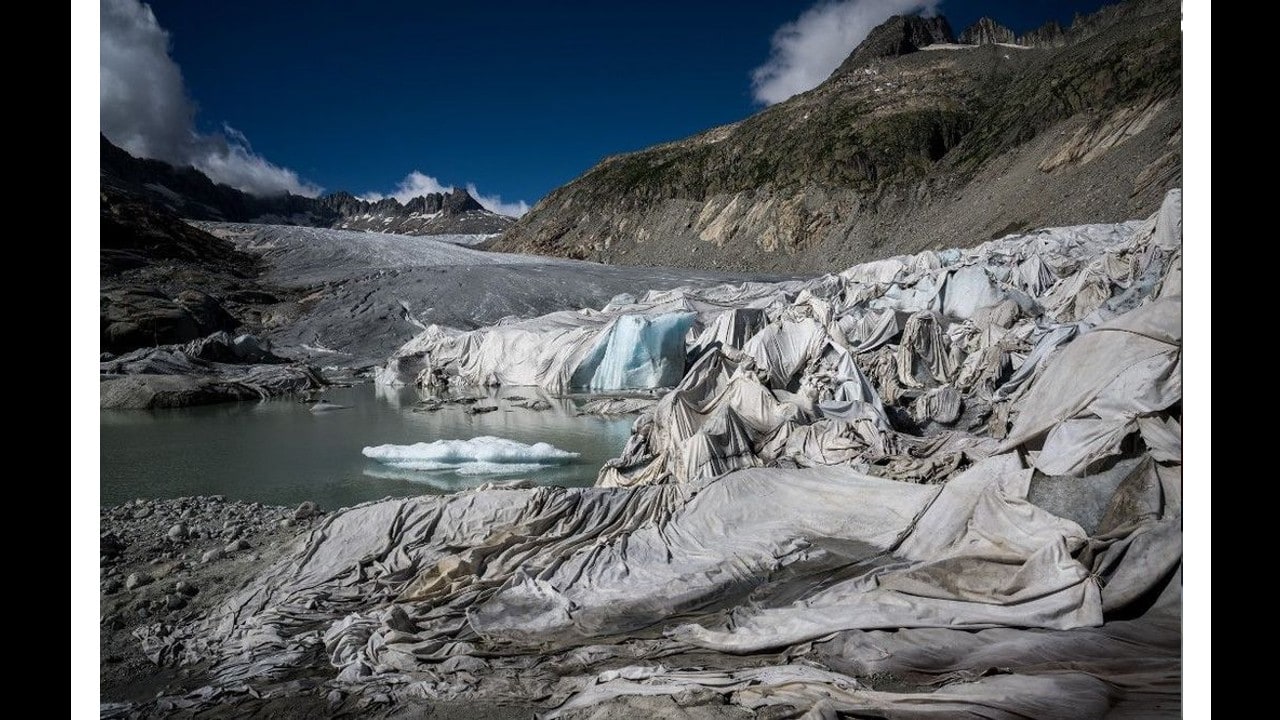 This photograph taken on July 8, shows insulating foam blankets covering a part of the Rhone Glacier to prevent it from melting, next to its glacial lake, formed by the melting of the glacier due to global warming, near Gletsch, in the Swiss Alps. (Image: AFP)