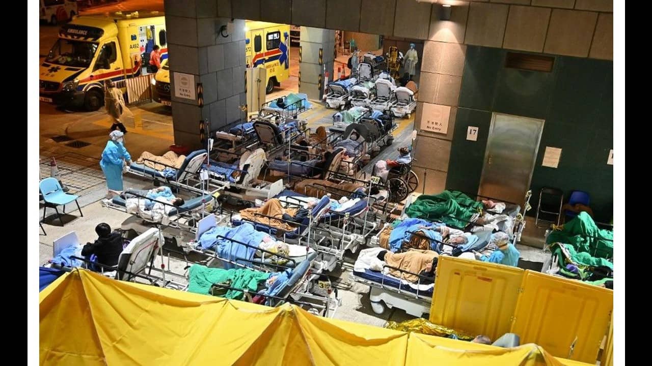 Patients lie in hospital beds outdoors while temperatures plummet at nighttime, outside the Caritas Medical Centre in Hong Kong on February 16, as the city faces its worst Covid-19 coronavirus wave to date, overwhelming hospitals. (Image: AFP)