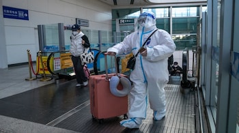 A traveler in protective gear at a train station in Beijing, China, on Wednesday, Dec. 21, 2022. China's broad budget deficit hit a record so far this year, showing how damaging the now abandoned Covid Zero policy and the ongoing housing slump have been to the economy and to the government's finances.