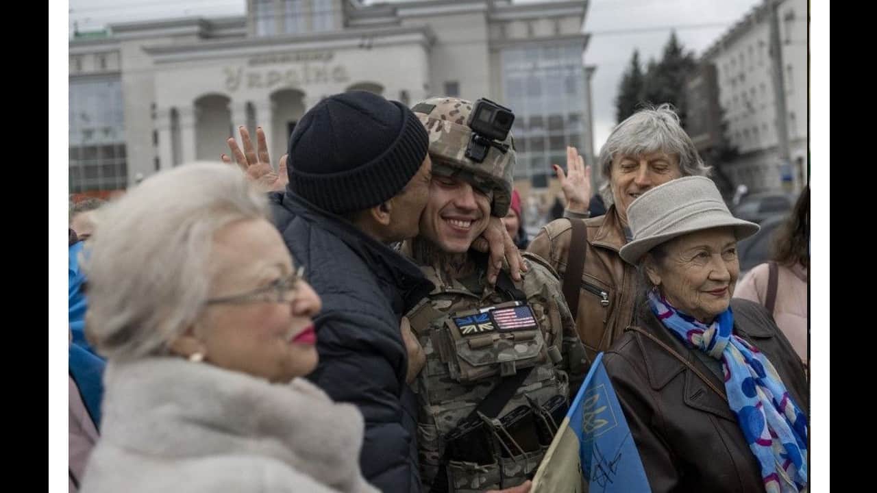 A man hugs a serviceman of the Ukrainian armed forces as local residents gather to celebrate the liberation of Kherson, on November 13. (Image: AFP)