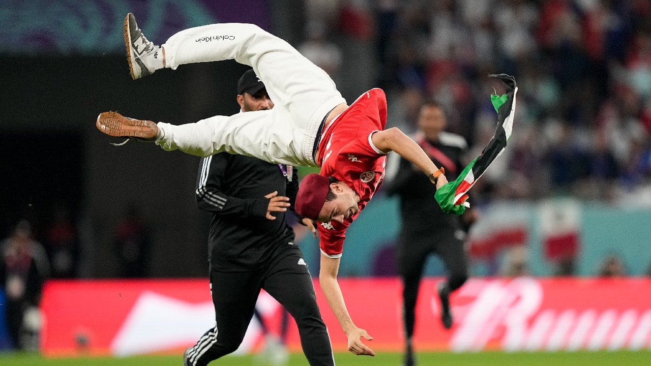 A pitch invader jumps during a World Cup group D soccer match between Tunisia and France at the Education City Stadium in Al Rayyan, Qatar. (Source: AP)