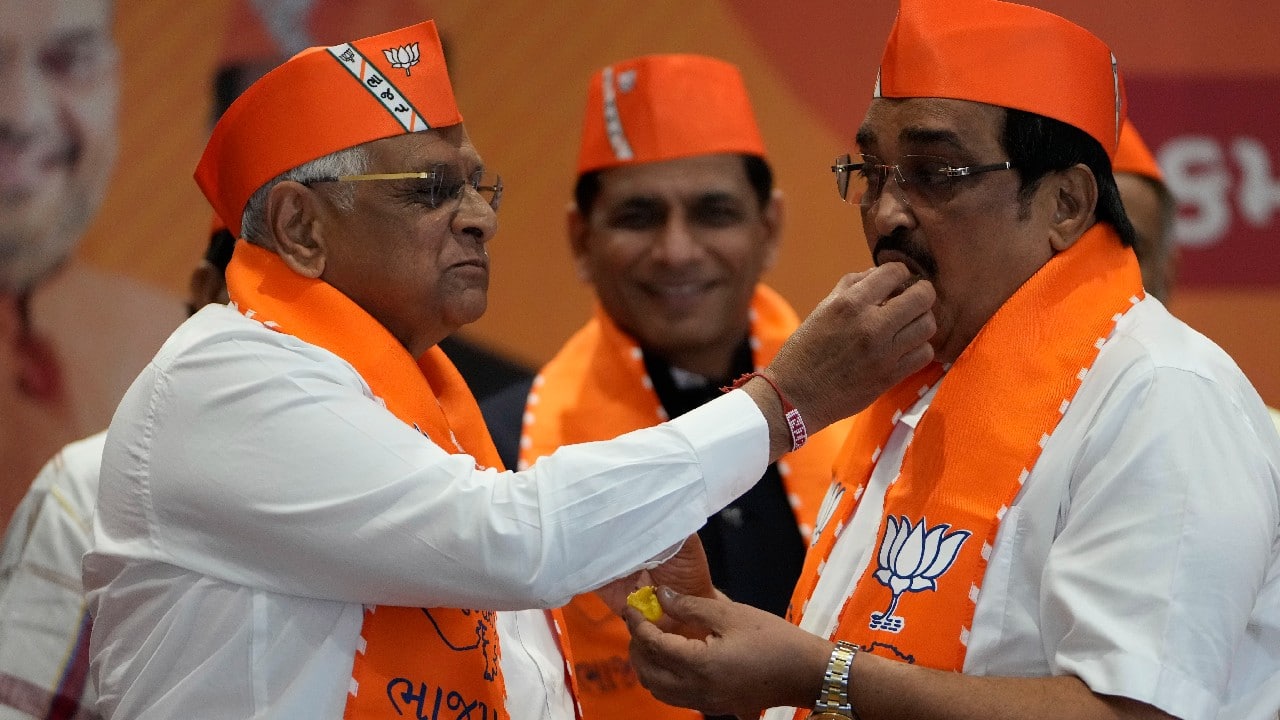 Gujarat Chief Minister Bhupendra Patel and BJP state President C R Patil, celebrate with sweets the lead for the party in Gujarat state elections in Gandhinagar. (Image: AP)