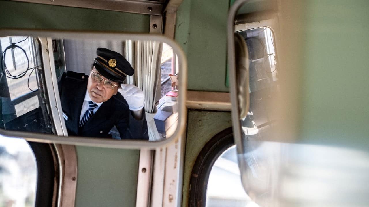 In the driver's seat of a two-carriage train, Katsunori Takemoto puts on his white gloves and checks the antiquated gauges before setting out alongside cabbage fields in Japan's rural Chiba. Like many small railway lines across Japan's countryside, the 60-year-old trains that ply this route are a loss-maker, but Takemoto has found a way to keep the business afloat. (Image: AFP)