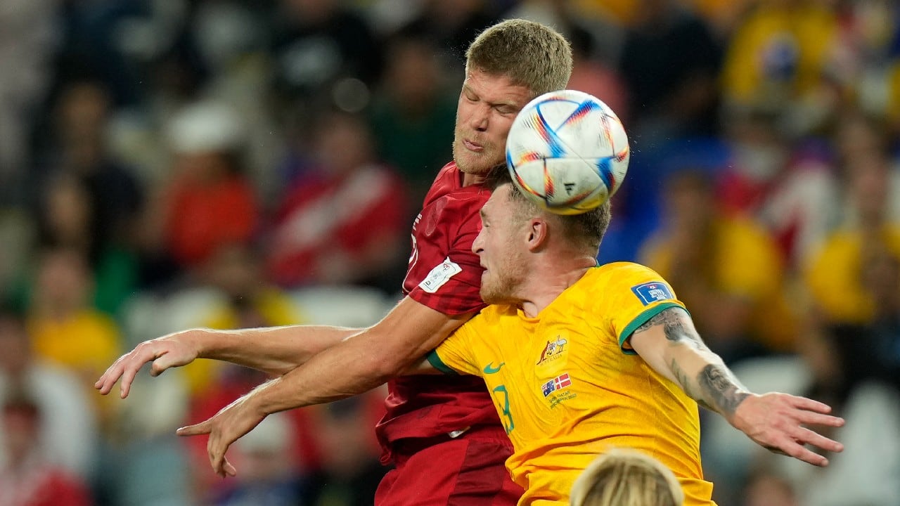 Denmark's Andreas Cornelius, left, and Australia's Harry Souttar jump for the ball during the World Cup group D soccer match between Australia and Denmark, at the Al Janoub Stadium in Al Wakrah, Qatar. (Source: AP)