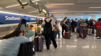 Travelers wait at a Southwest Airlines baggage counter at Los Angeles airport (AP Photo)