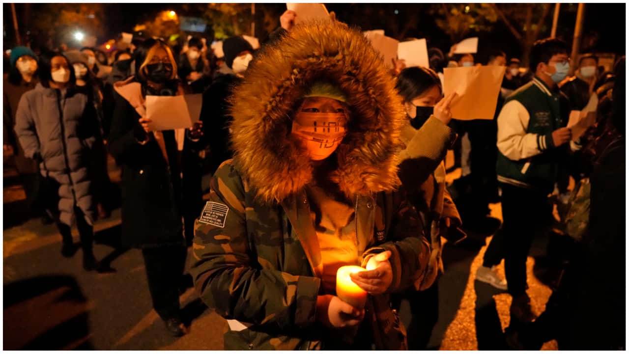 1)Protesters hold up blank papers and chant slogans as they march in protest against strict anti-virus measures in Beijing, Sunday, Nov. 27, 2022. (AP Photo/Ng Han Guan) 