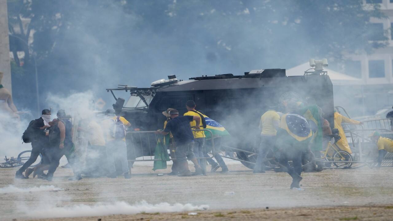 Protesters, supporters of Brazil's former President Jair Bolsonaro, attack a police armored vehicles as they storm the Planalto Palace in Brasilia, Brazil. (Image: AP)