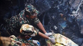 Rescuers inspect the site of a plane crash in Pokhara on Sunday.