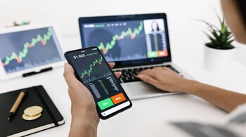 Young woman buying cryptocurrencies through mobile phone app. Stock market, investment and cryptocurrencies concept. Image: Getty Images