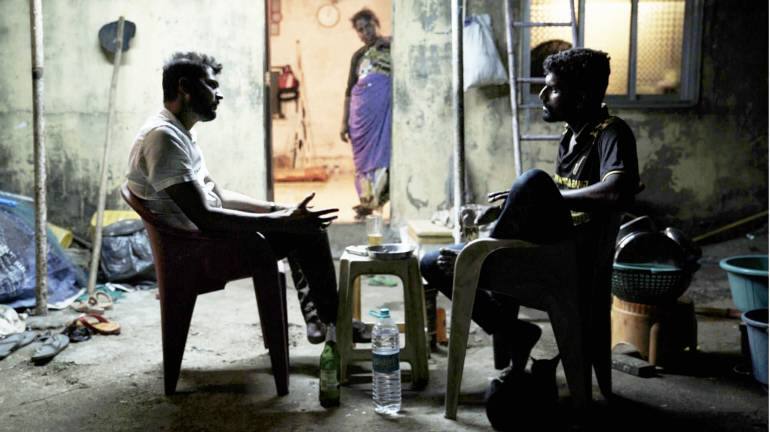 Ganesh with his best friend Rakesh, sitting outsude Rakesh's house as his mother looks on in a still rom Sarvnik Kaur's 'Against the Tide'. (Image courtesy of Snooker Club Films)